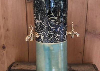 Fontaine à absinthe avec robinets dorés, 1 section bleue clair, 1 section motif feuille noir sur fond beige